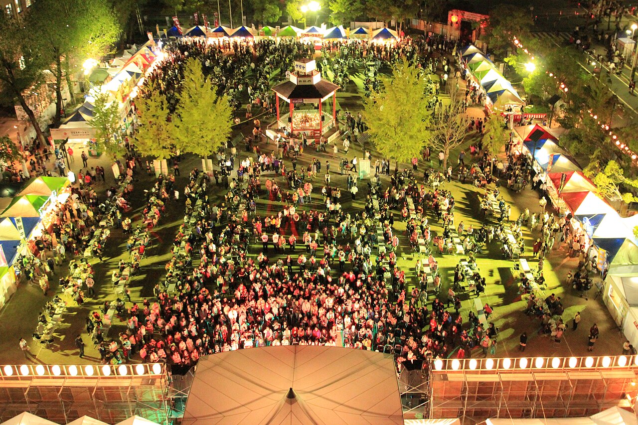 夜の広場に大勢の人が集まる酒まつりの会場